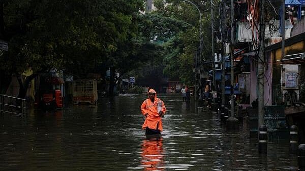 <div class="paragraphs"><p>A woman wades through a waterlogged street after heavy rains triggered by Cyclone Ditwah in Chennai.</p></div>