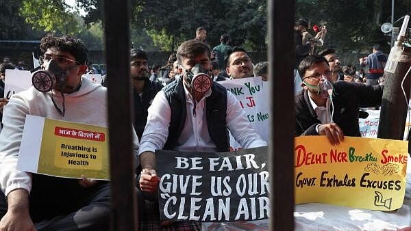 <div class="paragraphs"><p>Demonstrators, wearing masks, hold placards during a protest demanding government to take immediate steps to control air pollution in New Delhi</p></div>