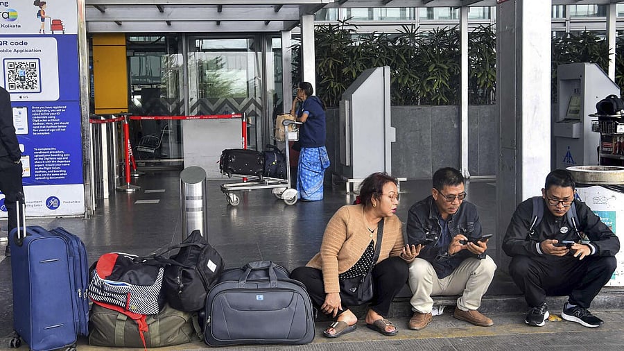 <div class="paragraphs"><p>Passengers look at their mobile phones as they wait amid IndiGo flight disruptions, at Netaji Subhash Chandra Bose International Airport in Kolkata, Saturday, Dec. 6, 2025.</p></div>