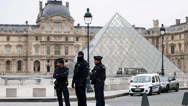 <div class="paragraphs"><p>Police officers stand near the pyramid of the Louvre museum after reports of a robbery, in Paris, France.</p></div>