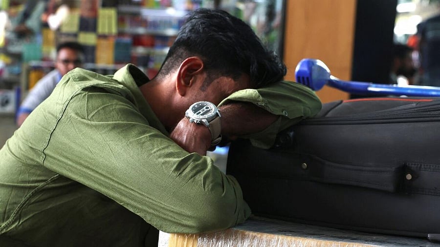 <div class="paragraphs"><p>A passenger naps on his luggage as he waits at Kempegowda International Airport in Bengaluru, India, December 6, 2025.</p></div>