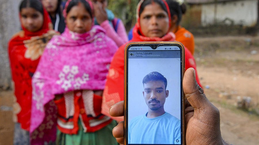 <div class="paragraphs"><p>A man holds a phone with a picture of Vinod Mahto (20), who died in a massive fire at a nightclub in North Goa that killed 25 people and left six others injured, in Ranchi, Sunday, Dec. 7, 2025.</p></div>