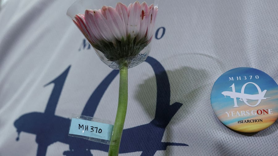 <div class="paragraphs"><p>A family member of the missing Malaysia Airlines flight MH370 holds a flower during a remembrance event</p></div>