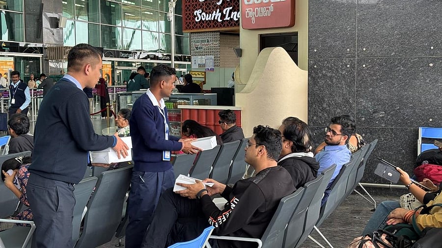 IndiGo staff tends to waiting passengers at Terminal 1 on Tuesday, providing snacks and juice.