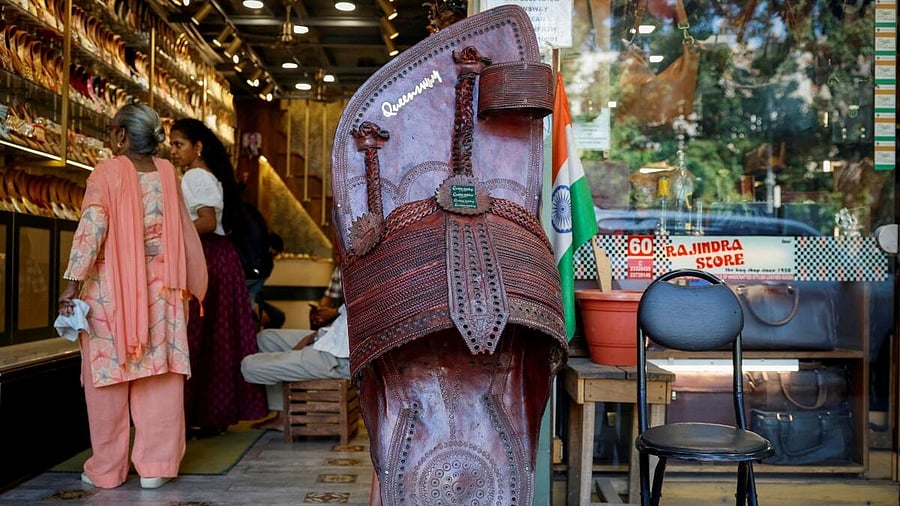 <div class="paragraphs"><p>Customers shop for 'Kolhapuri' sandals, an Indian ethnic footwear, at a store.</p></div>