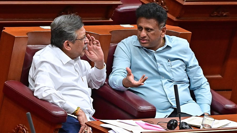 Higher Education Minister Dr M C Sudhakar has a word with Congress member M R Seetharam in the Legislative Council.