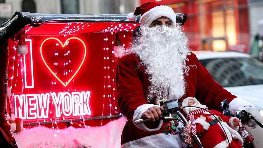 <div class="paragraphs"><p>A pedicab driver in a Santa Claus outfit cycles through New York. Credit: Reuters</p></div>