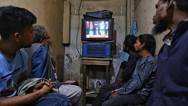 <div class="paragraphs"><p>People watch TV at a tea stall as Bangladeshi Chief Election Commissioner AMM Nasir Uddin announces the schedule for the national election, in Dhaka.</p></div>