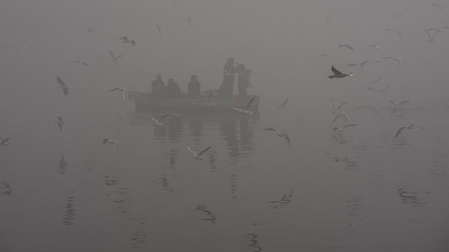<div class="paragraphs"><p>People take a boat ride at the Yamuna river amid low visibility due to a layer of smog, in New Delhi.</p></div>
