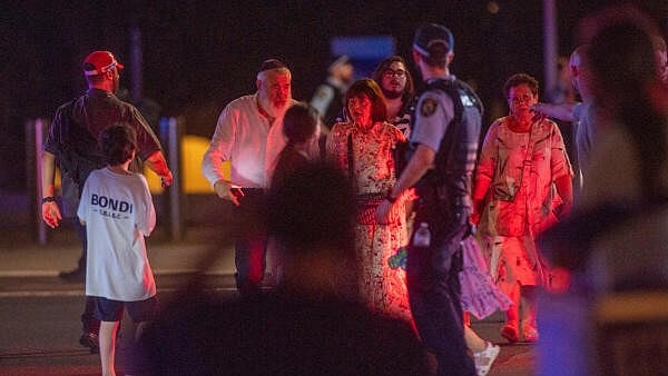 <div class="paragraphs"><p>People walk as police officers stand guard on the street following a shooting incident at Bondi Beach, in Sydney, Australia.</p></div>