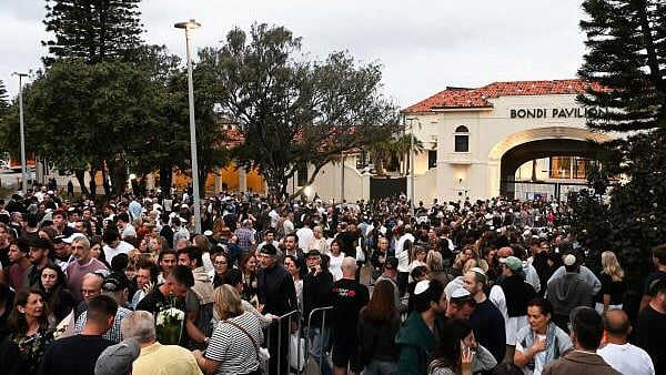 <div class="paragraphs"><p>People gather to pay tribute to the victims of a mass shooting that targeted a Jewish holiday celebration on Sunday at Bondi Beach, in Sydney</p></div>