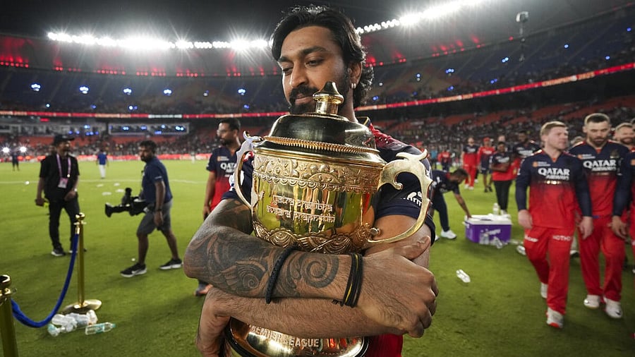 <div class="paragraphs"><p>Royal Challengers Bengaluru’s Krunal Pandya holds the Indian Premier League (IPL) 2025 championship trophy during the team's victory lap at the Narendra Modi Stadium, in Ahmedabad.</p></div>