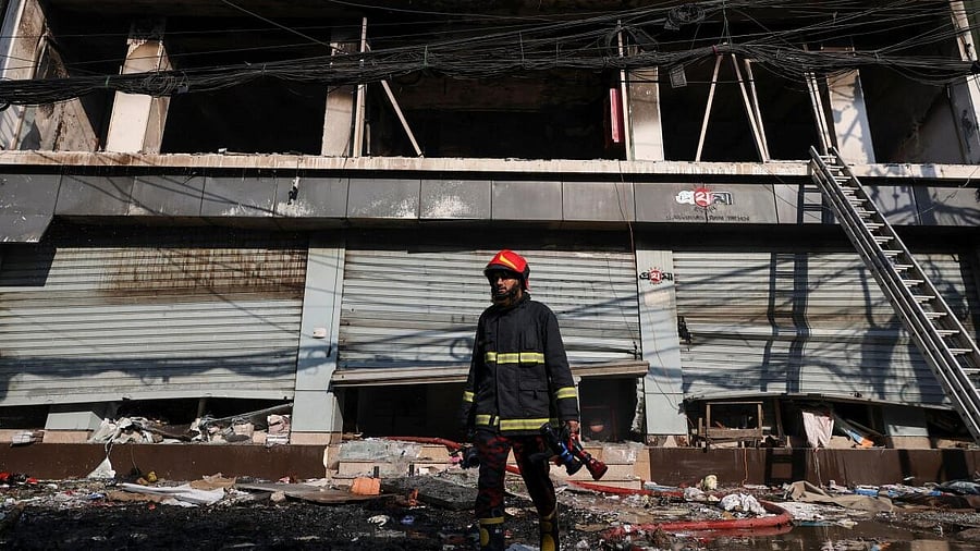 <div class="paragraphs"><p>A firefighter walks in front of the building of the vandalised office of Prothom Alo newspaper, following the death of Sharif Osman Hadi, a student leader, who was undergoing treatment in Singapore after being in shot the head, in Dhaka, Bangladesh, December 19, 2025.</p></div>