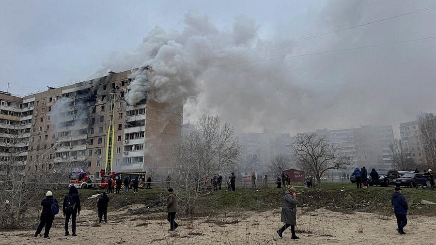 <div class="paragraphs"><p>Residents walk in front of an apartment building hit by a Russian air strike, amid Russia's attack on Ukraine.</p></div>