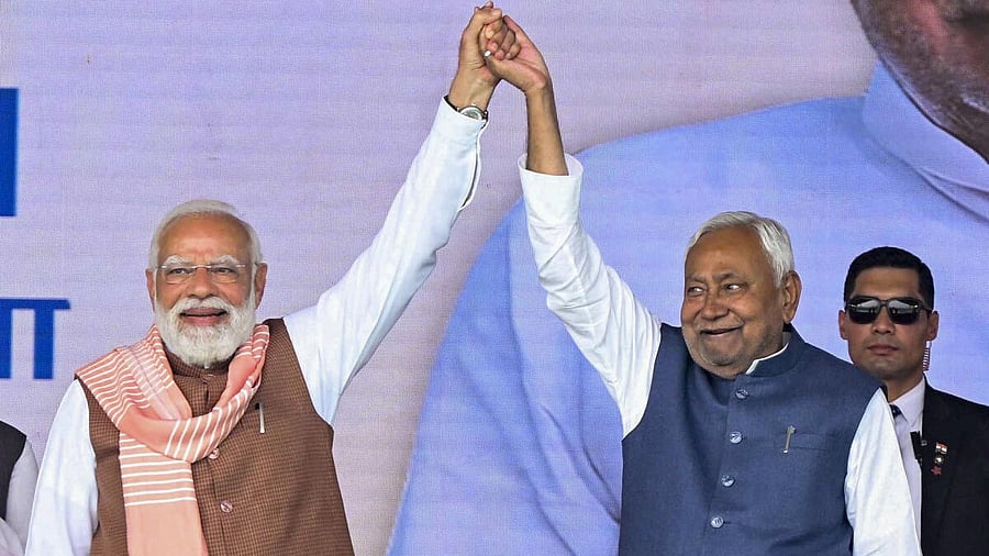 <div class="paragraphs"><p>Prime Minister Narendra Modi raises the hand of Bihar Chief Minister Nitish Kumar after the swearing-in ceremony, at Gandhi Maidan, in Patna.</p></div>