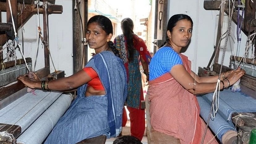 Weavers draped in naturally dyed Patteda Anchu sarees engaged in weaving. Photo by author