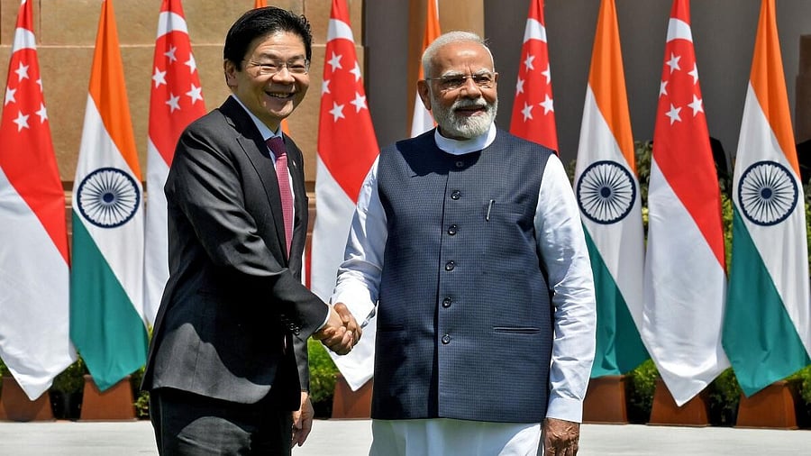 <div class="paragraphs"><p>Prime Minister Narendra Modi shakes hands with Singapore Prime Minister Lawrence Wong (L).</p></div>