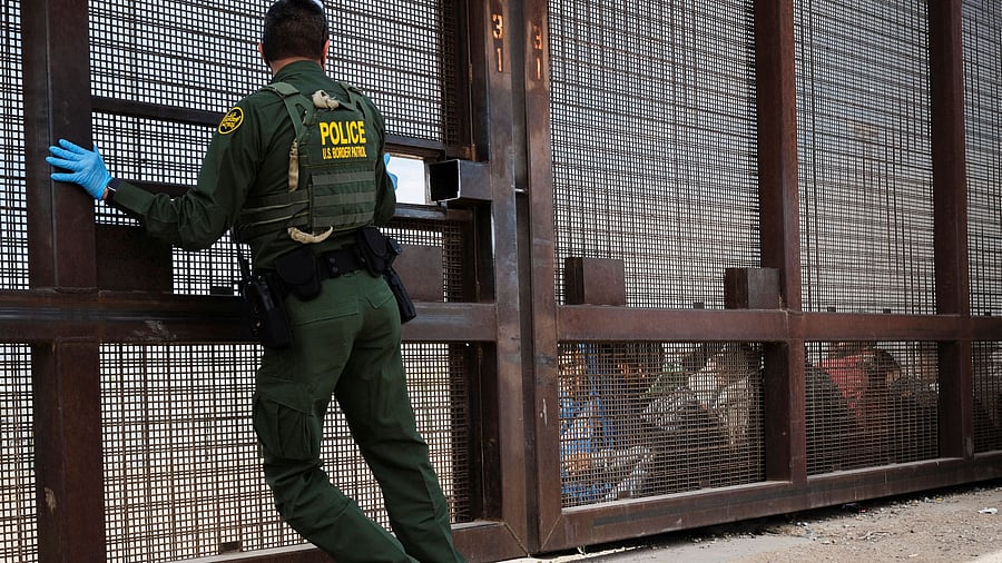 <div class="paragraphs"><p>A file photo of a border patrol agent opening a gate in the border wall in El Paso, Texas, US. </p></div>