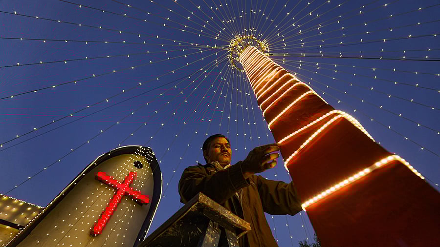<div class="paragraphs"><p>Ahmedabad: A man arranges decorative lights at the Church. </p></div>