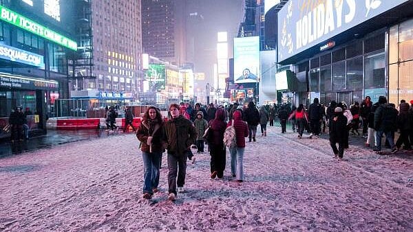 <div class="paragraphs"><p>People walk through Times Square during a winter storm in New York City, US.</p></div>