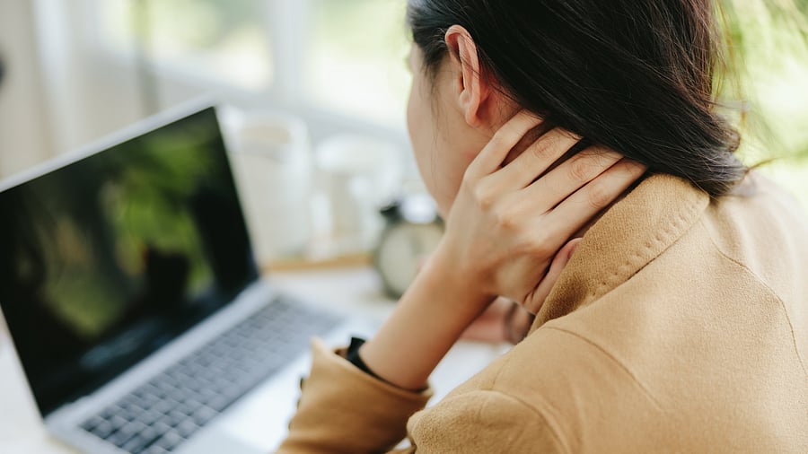 <div class="paragraphs"><p>Representative image of a woman massaging her neck while staring at a device screen.</p></div>