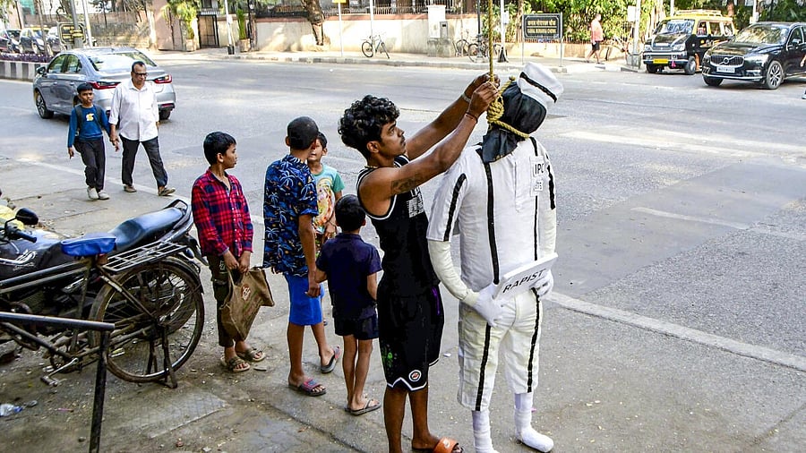 <div class="paragraphs"><p>A man hangs an effigy wearing a prisoner’s outfit to be burnt on the night of the new year, at Colaba, in Mumbai.</p></div>
