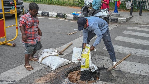 <div class="paragraphs"><p>BBMP workers filling sink road by building debris and Ready Asphalt Cbb mix at K L Rahul Circle near Minsk squire, Queens Road in Bengaluru</p></div>