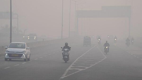 <div class="paragraphs"><p>Commuters make their way amid dense smog, with hazy conditions reducing visibility on a winter morning, in New Delhi.</p></div>