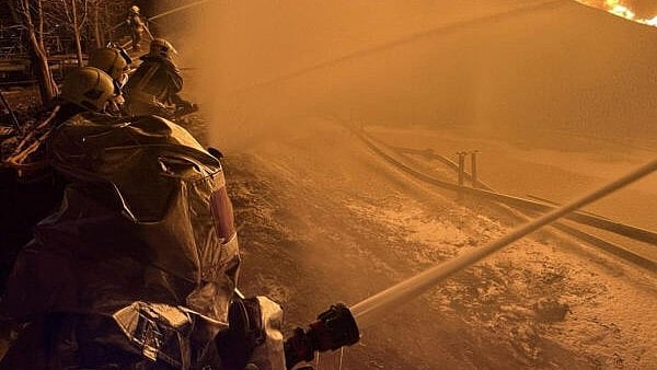 <div class="paragraphs"><p>Firefighters work at the site of a Russian drone strike.</p></div>
