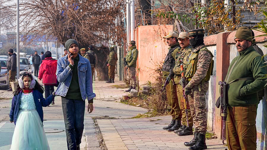 <div class="paragraphs"><p>People pass by as security personnel stand guard.</p></div>