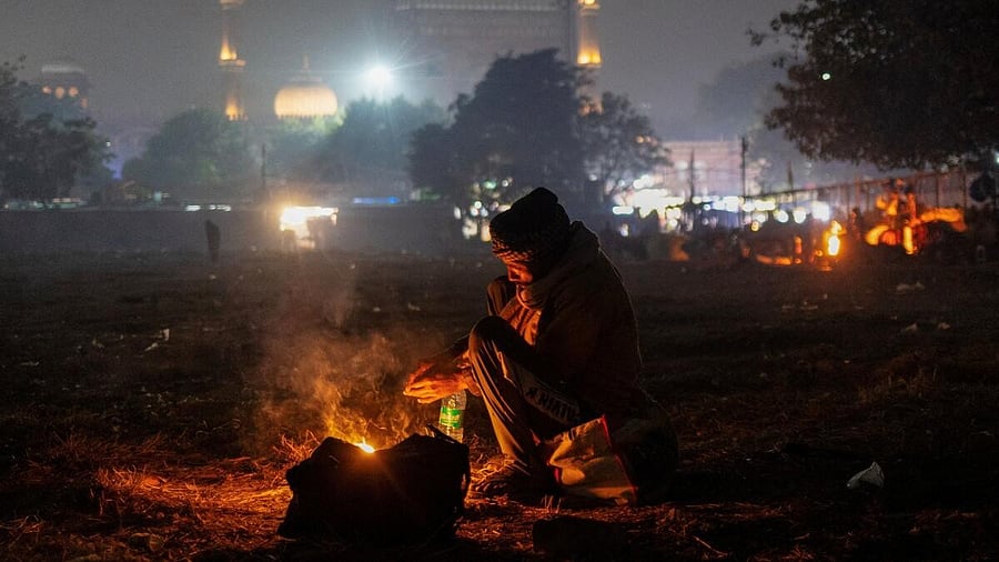 <div class="paragraphs"><p>A man warms himself by a fire in front of the Jama Masjid on a cold winter evening in the old quarters of Delhi.</p></div>