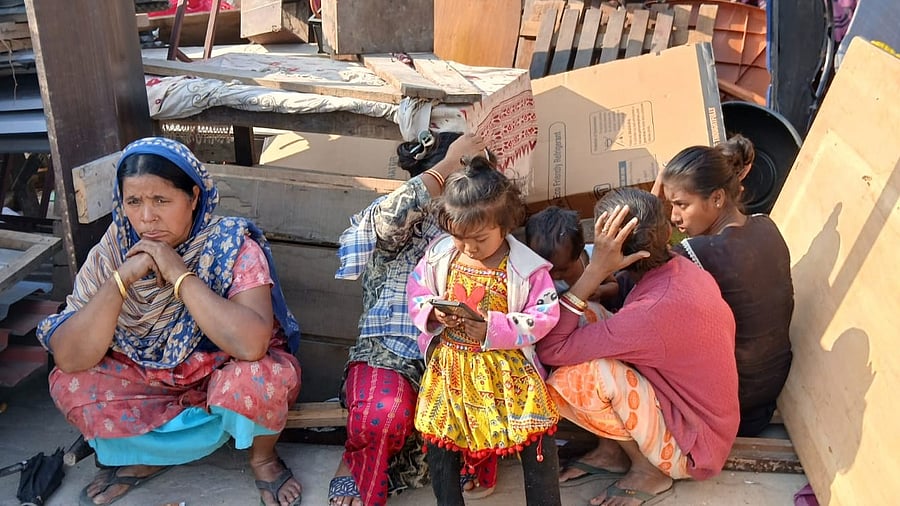 <div class="paragraphs"><p>A family sits outside their demolished home.</p></div>
