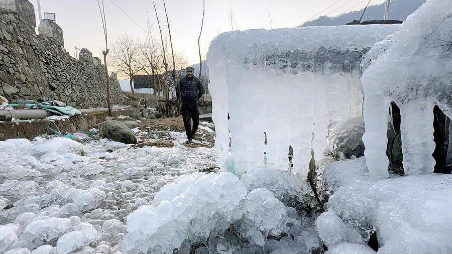 <div class="paragraphs"><p> A man walks past icicles hanging from a structure amid heavy frost and snow cover during a cold wave in the valley, in Anantnag district.</p></div>