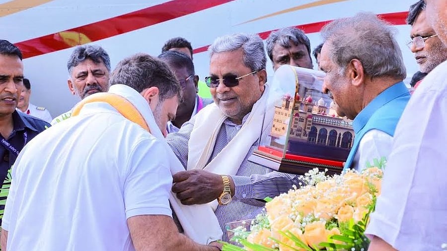 <div class="paragraphs"><p>Chief Minister Siddaramaiah, his and deputy D K Shivakumar receive Rahul Gandhi at Mysuru Airport on Tuesday.  </p></div>