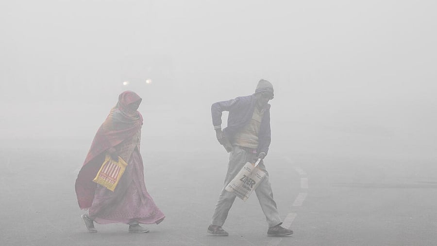 <div class="paragraphs"><p>People cross a road amid dense fog during a cold winter morning, in New Delhi.</p></div>