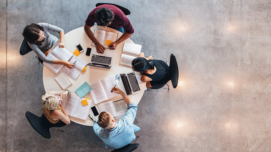 <div class="paragraphs"><p>Top view of group of students sitting together at table. University students doing group study. </p></div>