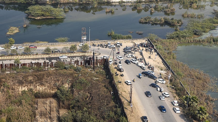 <div class="paragraphs"><p>People gather near a water-filled pit at a construction site following the death of a 27-year-old engineer who drowned, in Noida.</p></div>