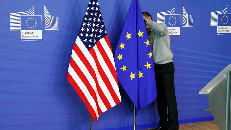 <div class="paragraphs"><p>A worker adjusts European Union and U.S. flags at the EU Commission headquarters in Brussels.</p></div>