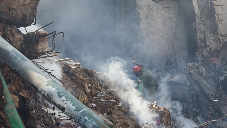 <div class="paragraphs"><p>A rescue worker walks amid rubble and smoke to search for survivors at the site, following a massive fire that broke out at the Gul Plaza Shopping Mall, in Karachi, Pakistan.</p></div>