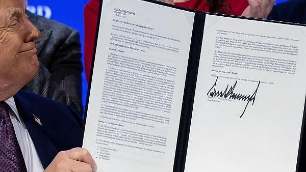 <div class="paragraphs"><p>US President Donald Trump holds a signed resolution, as he attends a charter announcement for his Board of Peace initiative aimed at resolving global conflicts, alongside the 56th annual World Economic Forum (WEF), in Davos, Switzerland.</p></div>
