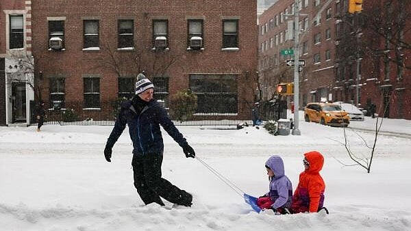 <div class="paragraphs"><p>A parent pulls his children on a sled along a sidewalk as a major winter storm spreads across a large swath of the United States, in New York City, US.</p></div>