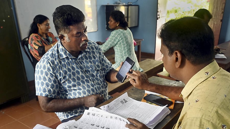 <div class="paragraphs"><p>A Booth Level Officer (BLO) interacts with a voter as he checks and collects filled enumeration forms for the special intensive revision (SIR) of electoral rolls.</p></div>