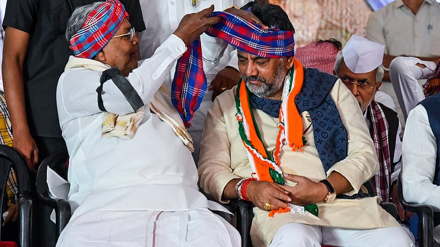<div class="paragraphs"><p>Chief Minister Siddaramaiah wraps a turban around the head of his&nbsp;deputy and KPCC president D K Shivakumar during the&nbsp;'Lok Bhavan chalo' protest against the scrapping of the MGNREGA, at Freedom Park in Benglauru on Tuesday. </p></div>