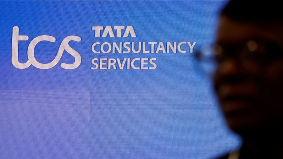 <div class="paragraphs"><p>A man walks past a logo of Tata Consultancy Services (TCS).</p></div>