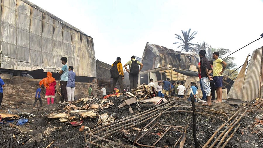 <div class="paragraphs"><p>People gather near the charred remains of a fire at a warehouse, in Kolkata.</p></div>