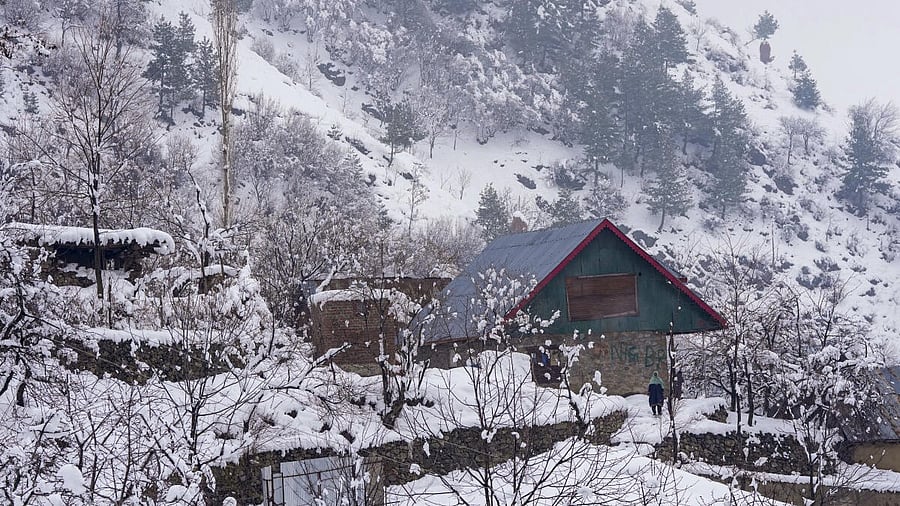 <div class="paragraphs"><p>A woman stands at a snow-covered area outside her house after fresh snowfall, on the outskirts of Srinagar.</p></div>