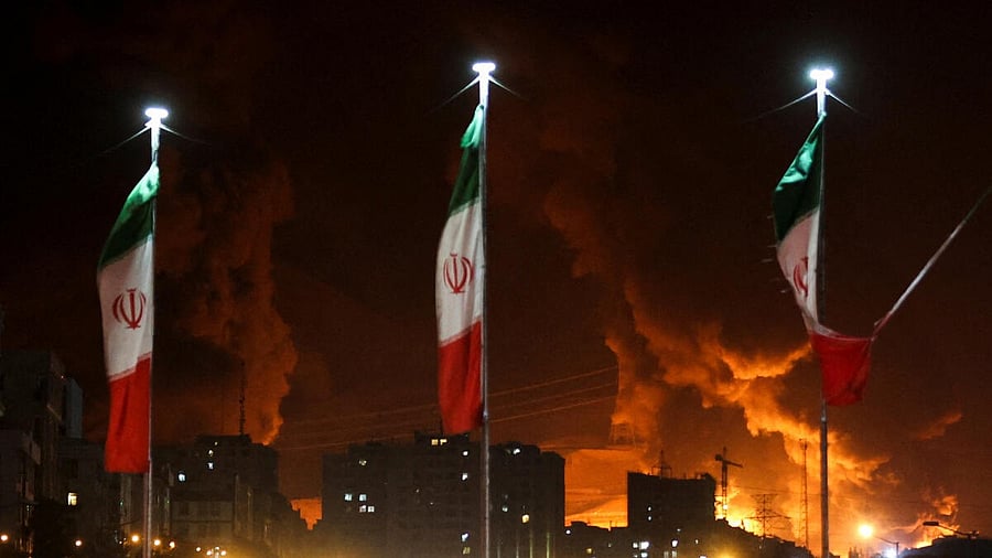 <div class="paragraphs"><p>Iranian flags fly as fire and smoke from an Israeli attack on Sharan Oil depot rise, following Israeli strikes on Iran, in Tehran, Iran.</p></div>