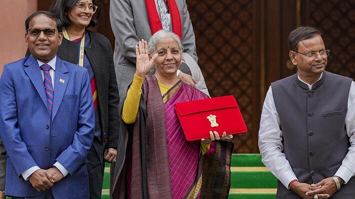 <div class="paragraphs"><p>Finance Minister Nirmala Sitharaman holds the digital tablet, enclosed in a traditional red 'bahi-khata' style pouch, at the Parliament premises before presenting of the ‘Union Budget 2026-27’.</p></div>