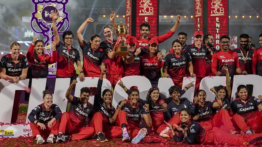 <div class="paragraphs"><p>Royal Challengers Bengaluru's players celebrate with the trophy after winning the Women's Premier League (WPL) 2026 final T20 cricket match against Delhi Capitals, at Baroda Cricket Association Stadium, Kotambi in Vadodara, Gujarat.</p></div>