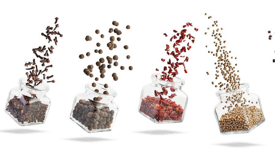 A set of spices in a glass jar levitating on a white background. Spice explosion.
spices